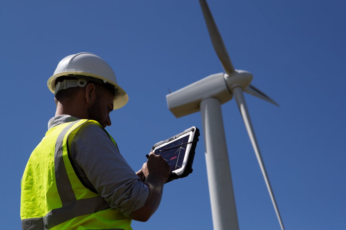 Wind farm engineer using the Panasonic TOUGHBOOK G2 mk2 (5G, EU plug) rugged tablet outdoors in direct sunlight